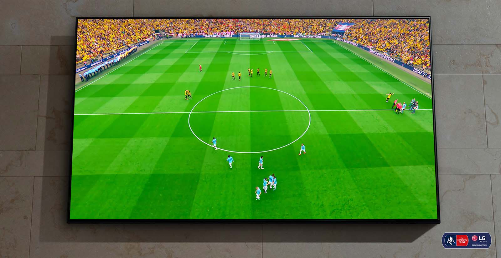 Ant sienos įrengtas „Nanocell“ TV. Ekrane rodoma futbolo rungtynių pradžia.