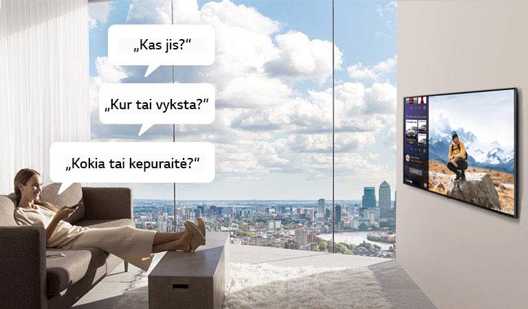 Televizorių žiūrinti moteris ir jo klausianti „Kas jis?“, „Kur tai vyksta?“ ir „Kokia tai kepuraitė?“ 