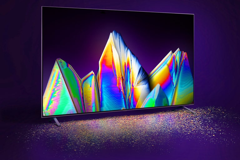 „Nanocell“ TV ir kristalas ekrane. Ant grindų matosi spalvų dalelės.