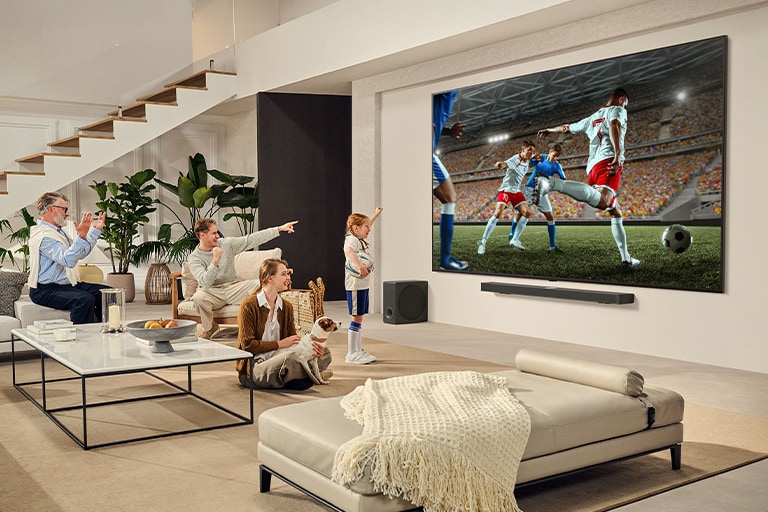 Šeima susirinkusi aplink itin didelį LG „Ultra Big“ TV ir didžiuliame jo ekrane stebi įdomias futbolo rungtynes.