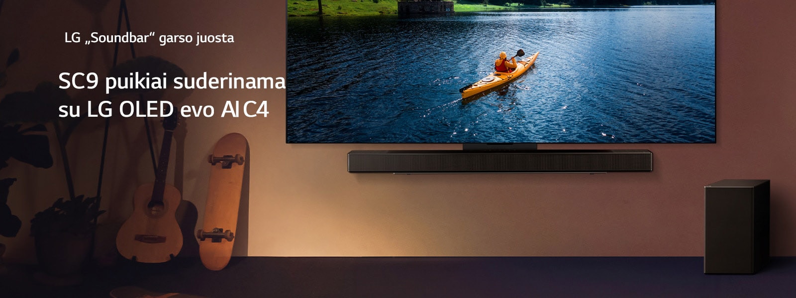 LG TV ir „Soundbar“ sumontuoti prie sienos, o žemųjų dažnių garsiakalbis pastatytas ant grindų, dešinėje. Televizoriuje rodomas baidare per ežerą plaukiantis žmogus; ant sienos sklinda švelnūs šešėliai.