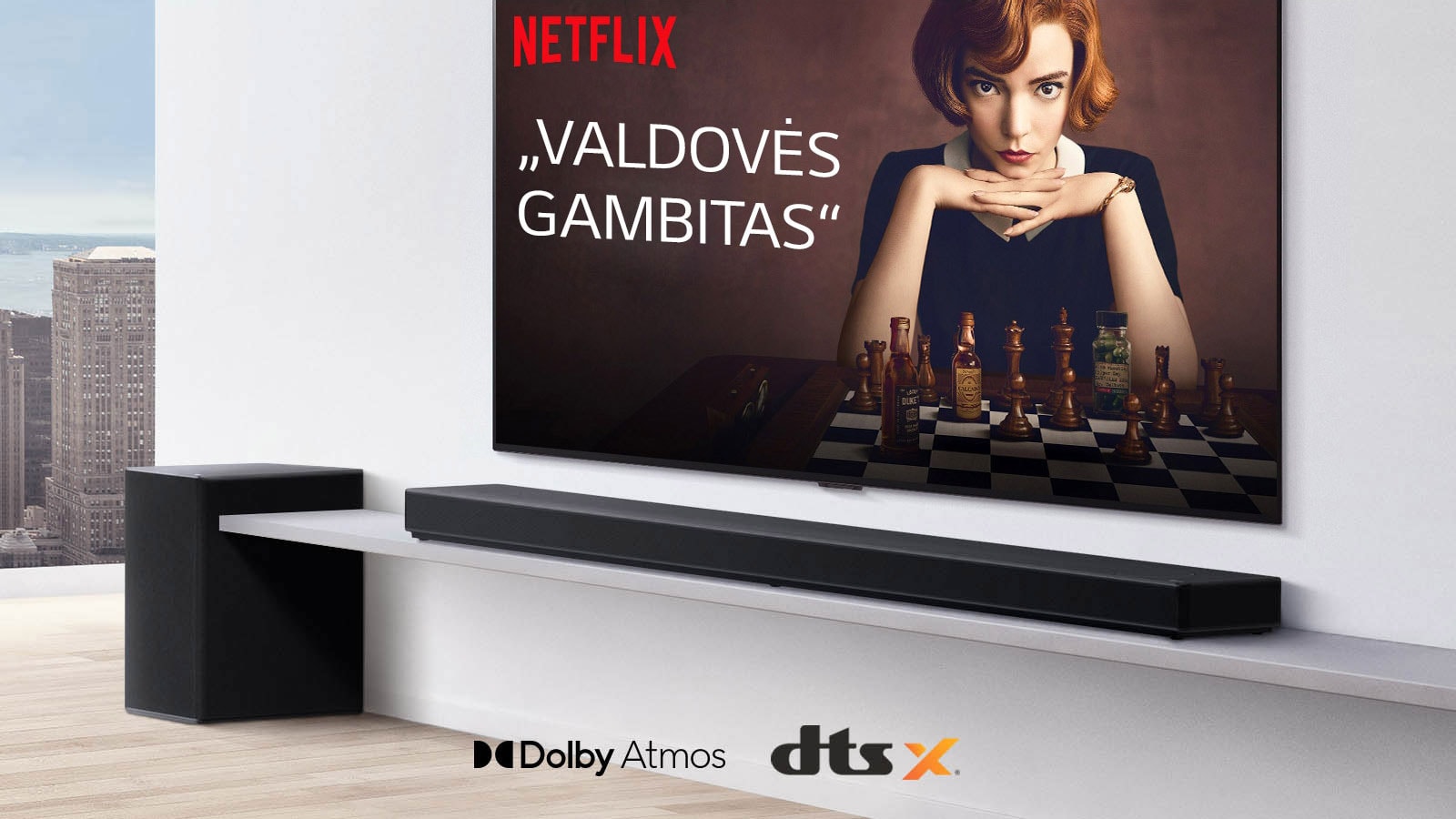 Ant sienos įrengtas televizorius. Televizoriaus ekrane rodomas TV laidos plakatas. „LG Soundbar“ yra tiesiai po televizoriumi ant baltos lentynos, o šalia yra žemadažnis garsiakalbis. Paveikslėlio apatinėje vidurinėje dalyje yra „Dolby Atmos“ ir DTS:X logotipai.