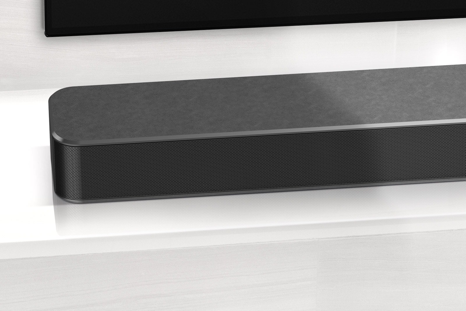„LG Soundbar“ kairiojo kampo vaizdas stambiu planu. Taip pat matoma televizoriaus apatinė kairioji pusė.