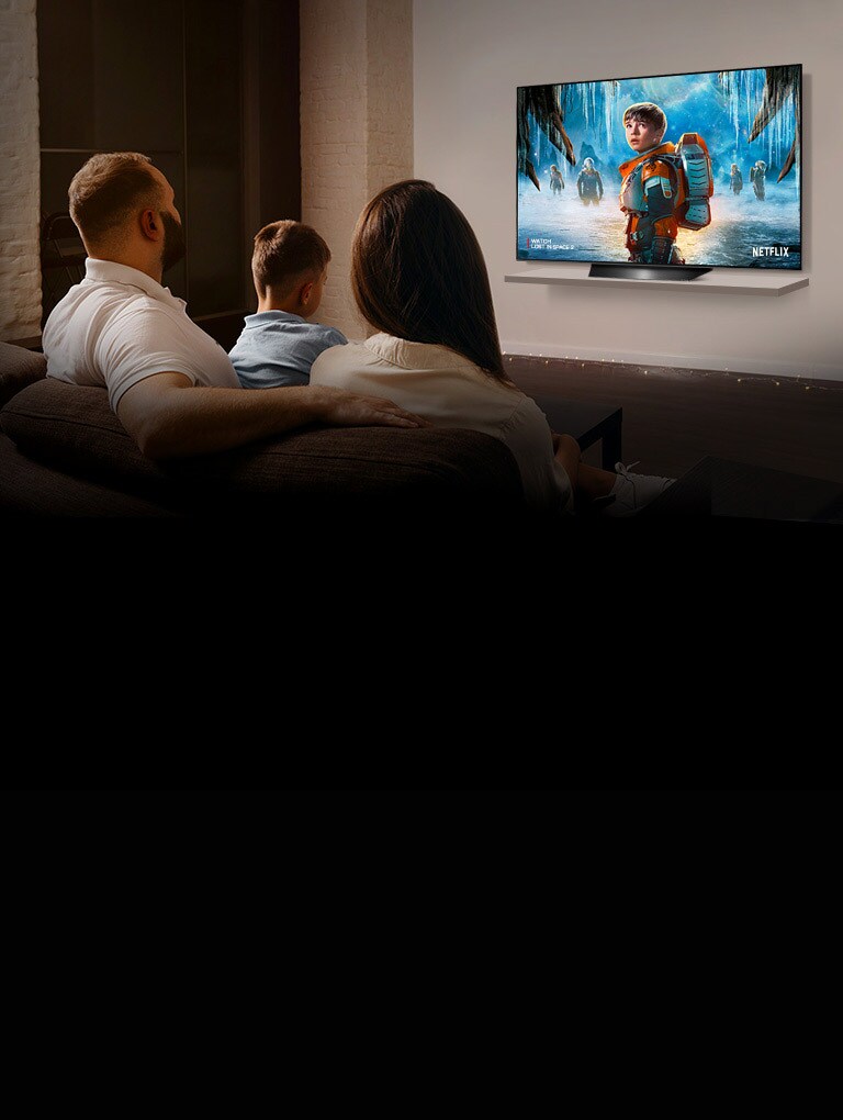 Svetainėje pora sėdi ant sofos ir per TV žiūri romantinį filmą