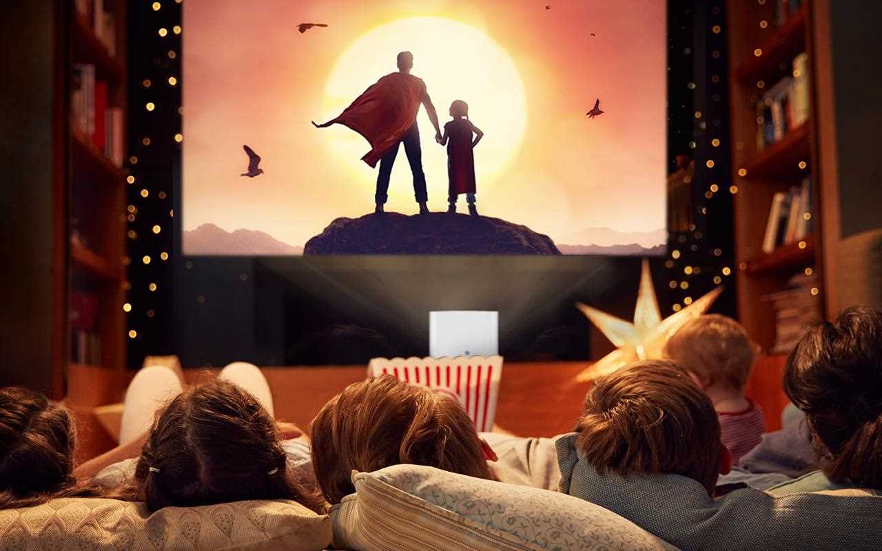 Šeima mėgaujasi namų kino kambariu.