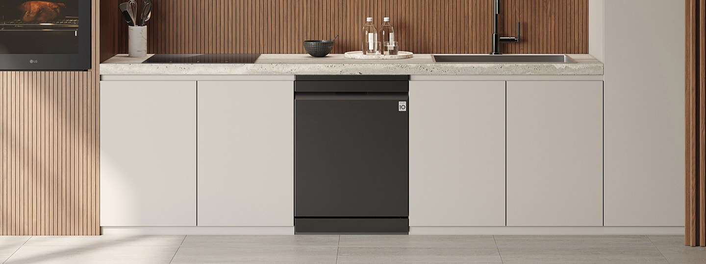 LG iebūvētā trauku mazgājamā mašīna ar elegantu iebūvētu paneļa dizainu uzstādīta vienā līmenī starp baltiem apakšējiem skapīšiem zem akmens virsmas, tā centrēta zem koka sienas apdares ar izlietni, pudelēm un bļodai atrodoties uz letes.