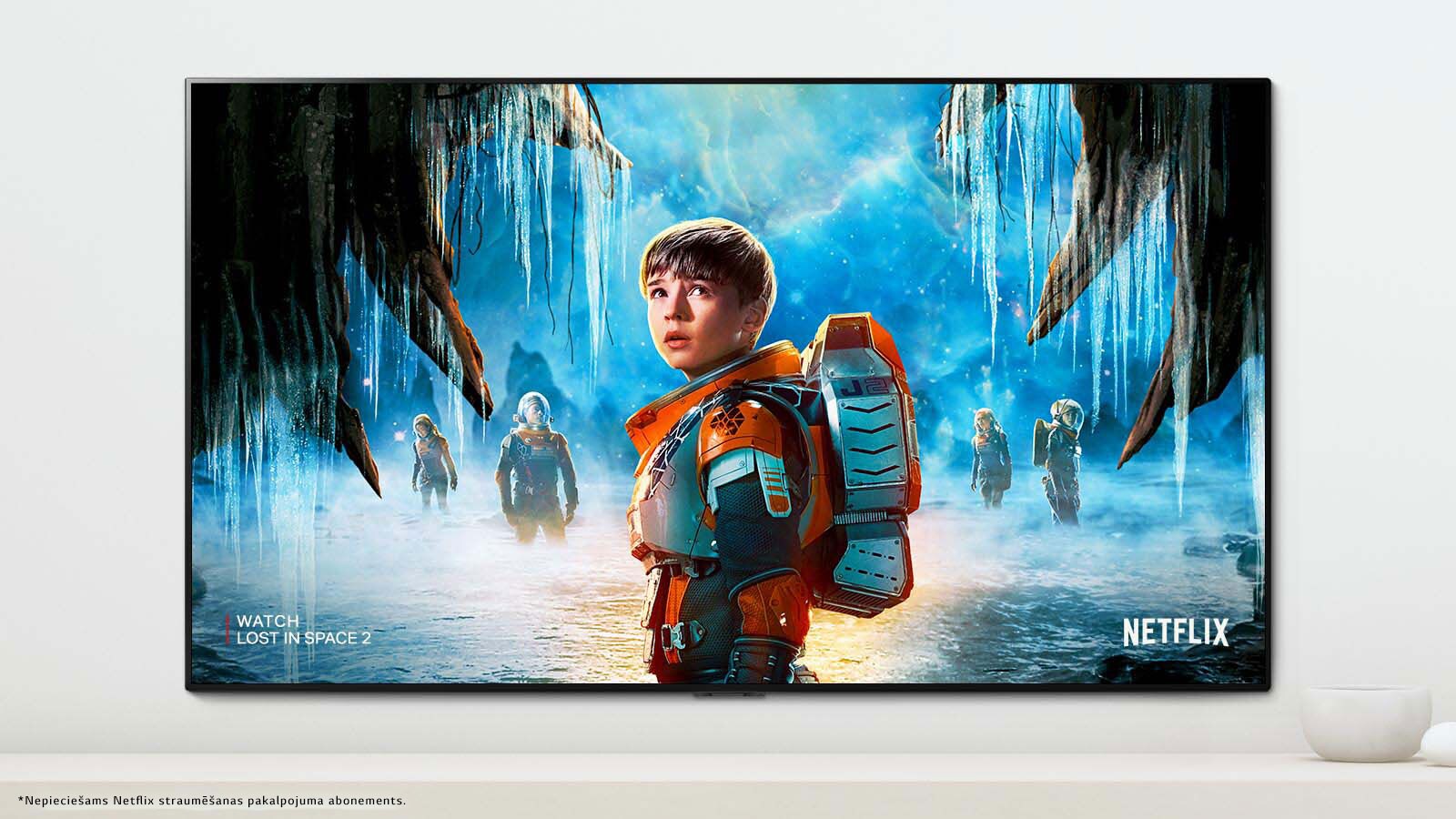 Televizora ekrānā redzama aina no seriāla “Lost in Space 2”, kurās galvenajiem varoņiem ir sasprings skatiens