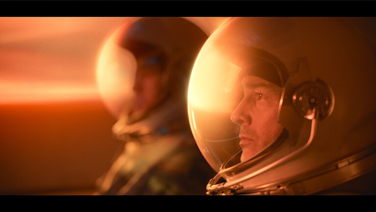 Vīrietis kinoteātra apstākļos skatās Netflix filmu Midnight Sky. Redzams arī sauklis “Esiet varonis”.