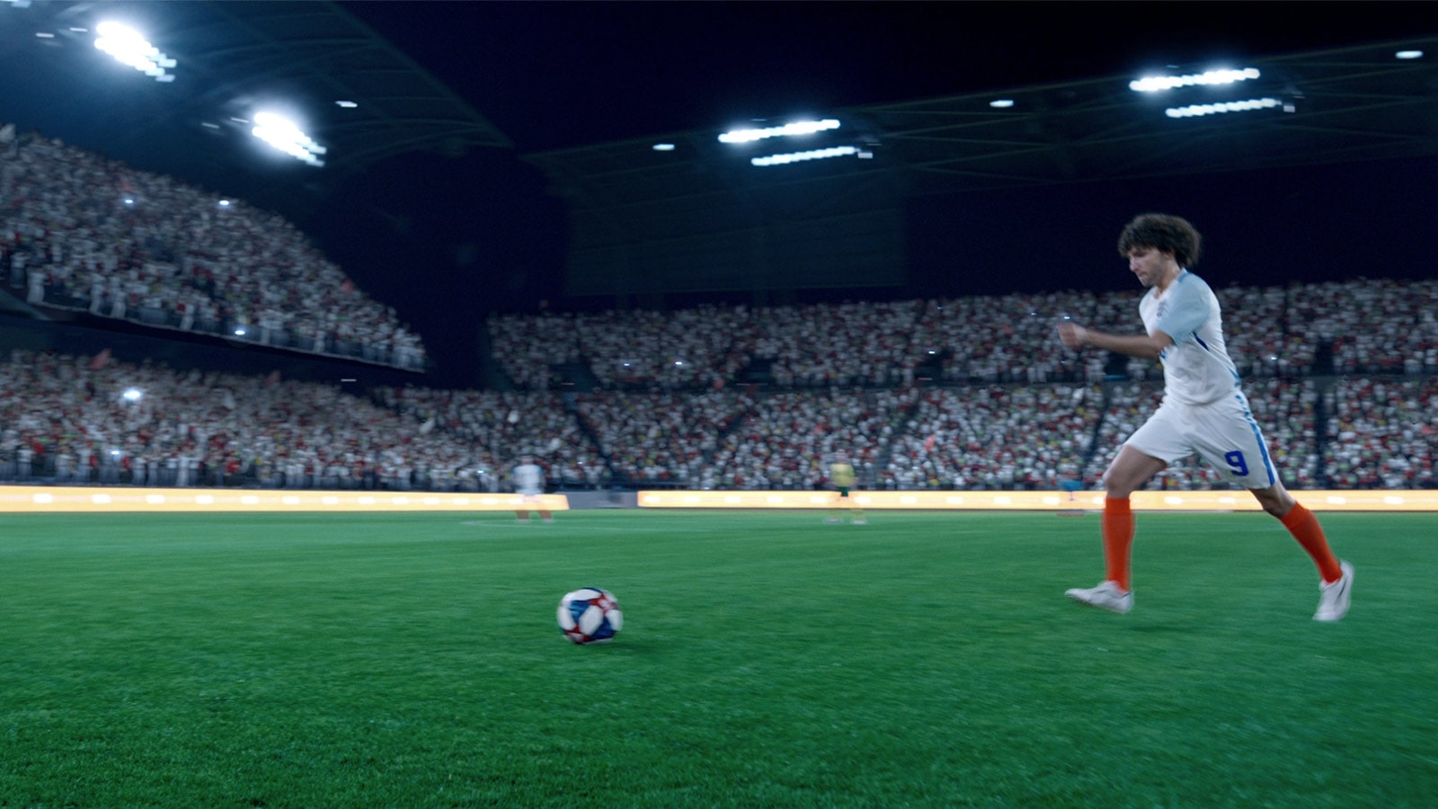 Vīrietis sēž dīvānā un ir iegrimis futbola spēles vērošanā. Skatīšanās laikā atnāk draugi, un viņi skatās kopā. Redzams logotips “Kļūstiet par superzvaigzni, izgaismojiet spēli”