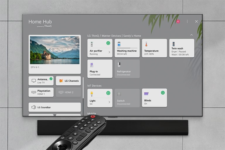 Dzīvojamajā istabā pārraidīts lielisks koncerts. WOW Interface izvēle parādās kadra priekšpusē, un lietotājs pārvietojas, izvēloties Soundbar iestatījumus. 
