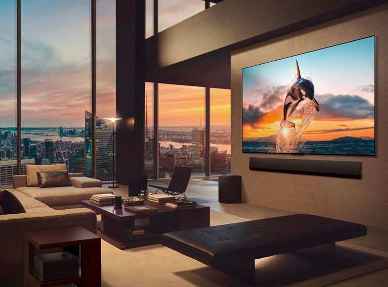 Plaša viesistaba ar skatu uz pilsētas ainavu. LG OLED TV ir piestiprināts pie sienas un LG Soundbar. TV vienas sienas dizains ļauj tam pilnībā piegult pie sienas un labi iekļauties telpā. Zero Connect Box ir redzams, bet paslēpts. 
