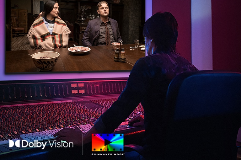 LG QNED evo AI QNED85 Mini LED redzams studijā, kur režisors strādā pie vadības paneļa, rediģējot ekrānā redzamo filmu. Dolby Vision logotips un FILMMAKER MODE logotips parādīti apakšējā kreisajā stūrī.