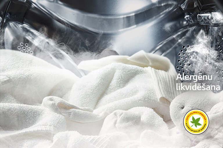 Balts halāts un mīkstā rotaļlieta redzama veļas mazgājamās mašīnas tvertnē, mazgājot ar tvaiku