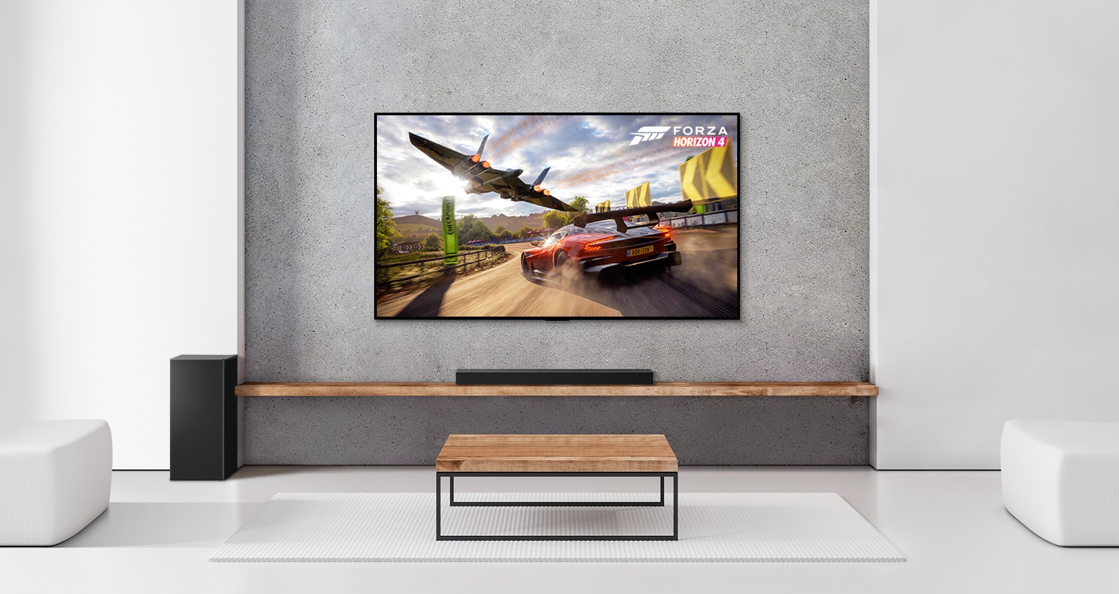 Baltā viesistabā redzami divi aizmugures skaļruņi, zemo frekvenču pastiprinātājs, skaņas josla un televizors. Televizora ekrānā redzama braucoša automašīna un kosmosa kuģis.