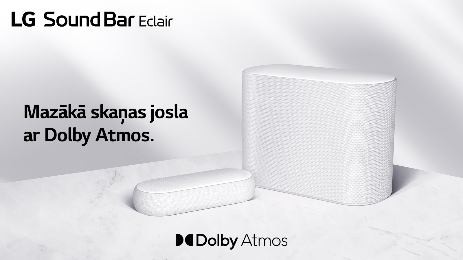 Uz marmora grīdas novietota skaņas josla un zemo frekvenču pastiprinātājs, kas ir pavērsti uz pretējām pusēm. Kreisajā augšējā stūrī redzams logotips “LG Sound Bar Éclair”, un teksts “Mazākā skaņas josla ar Dolby Atmos”. Zem skaņas joslas redzams logotips “Dolby Atmos”