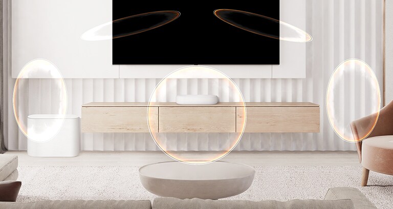 Skaņas josla ir izvietota uz koka skapīša zem televizora, un kreisajā pusē redzams zemo frekvenču pastiprinātājs. No skaņas joslas nāk skaņas viļņu efekts.