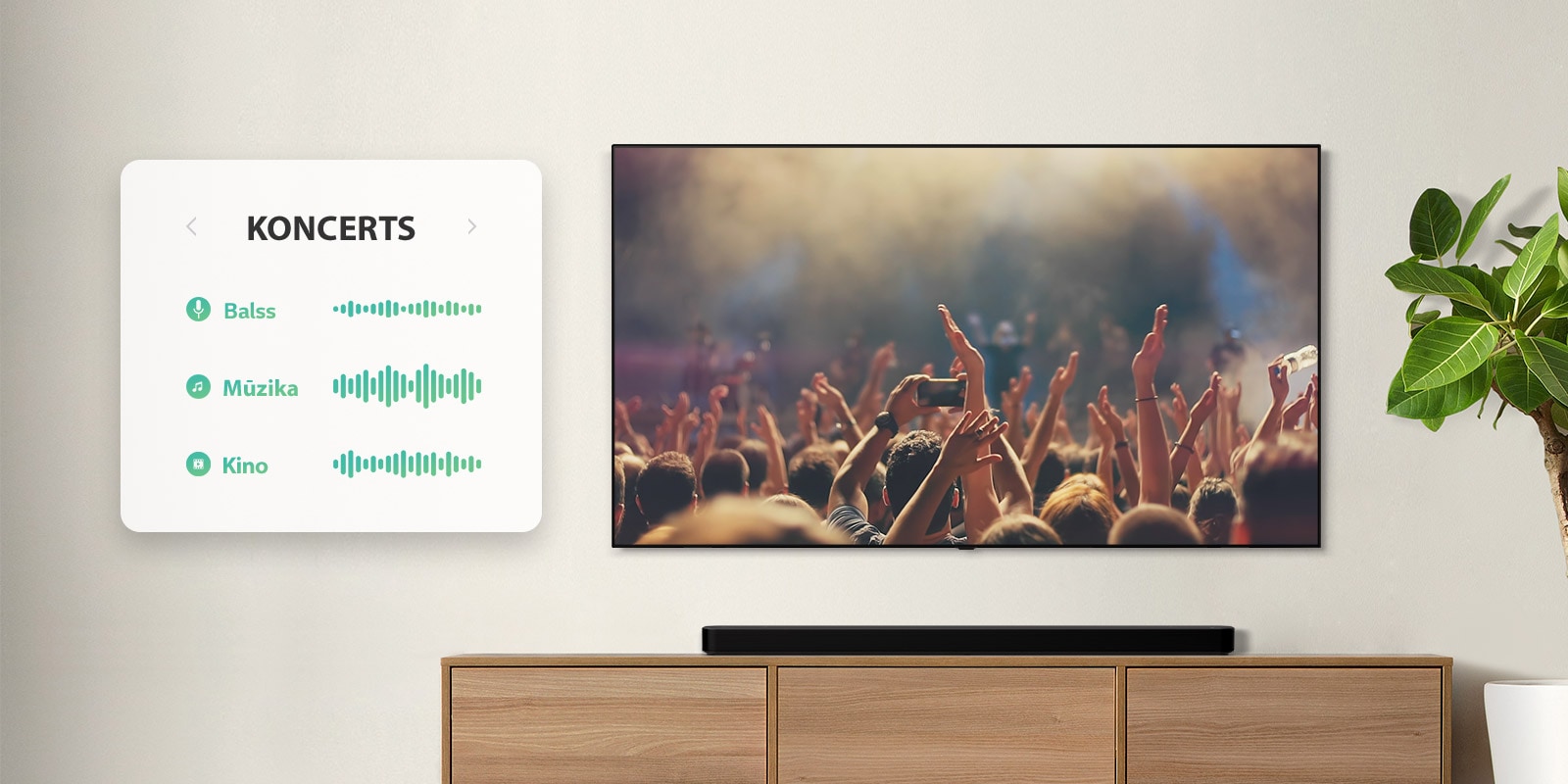 TV pie sienas. Televizorā redzami cilvēki, kas aplaudē koncertā, kanāls tiek pārslēgts uz filmu ainu ar pa mežu braucošu automašīnu, pēc tam kanāls tiek pārslēgts uz ziņām, un runā ziņu vadītājs. Tieši zem televizora uz smilškrāsas plaukta izvietota LG skaņas josla. (atskaņot video)