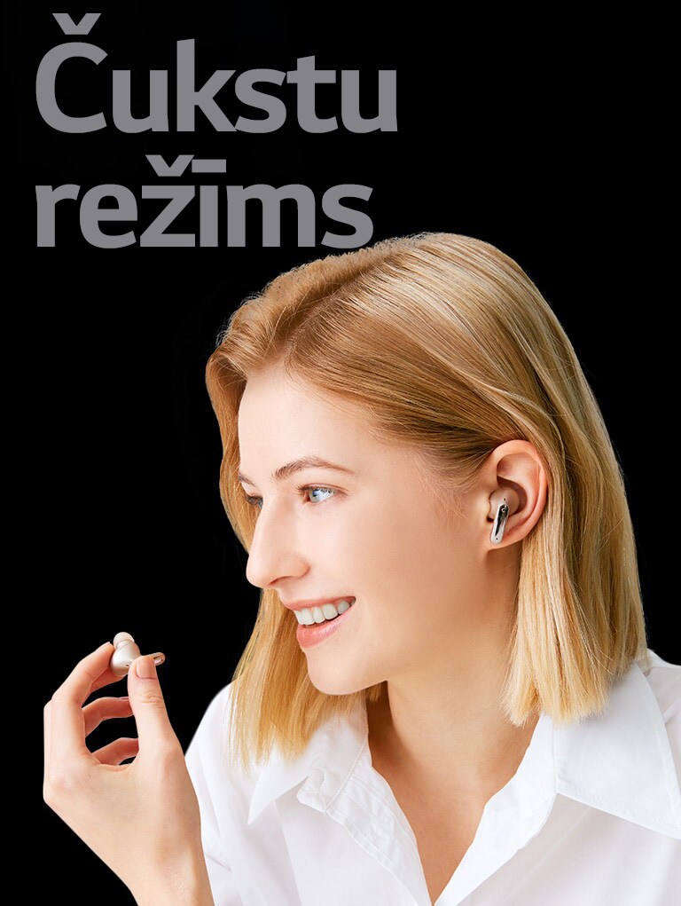 Attēlā redzama sieviete, kas rokā tur austiņas un izmanto tās kā mikrofonu zvana veikšanai.