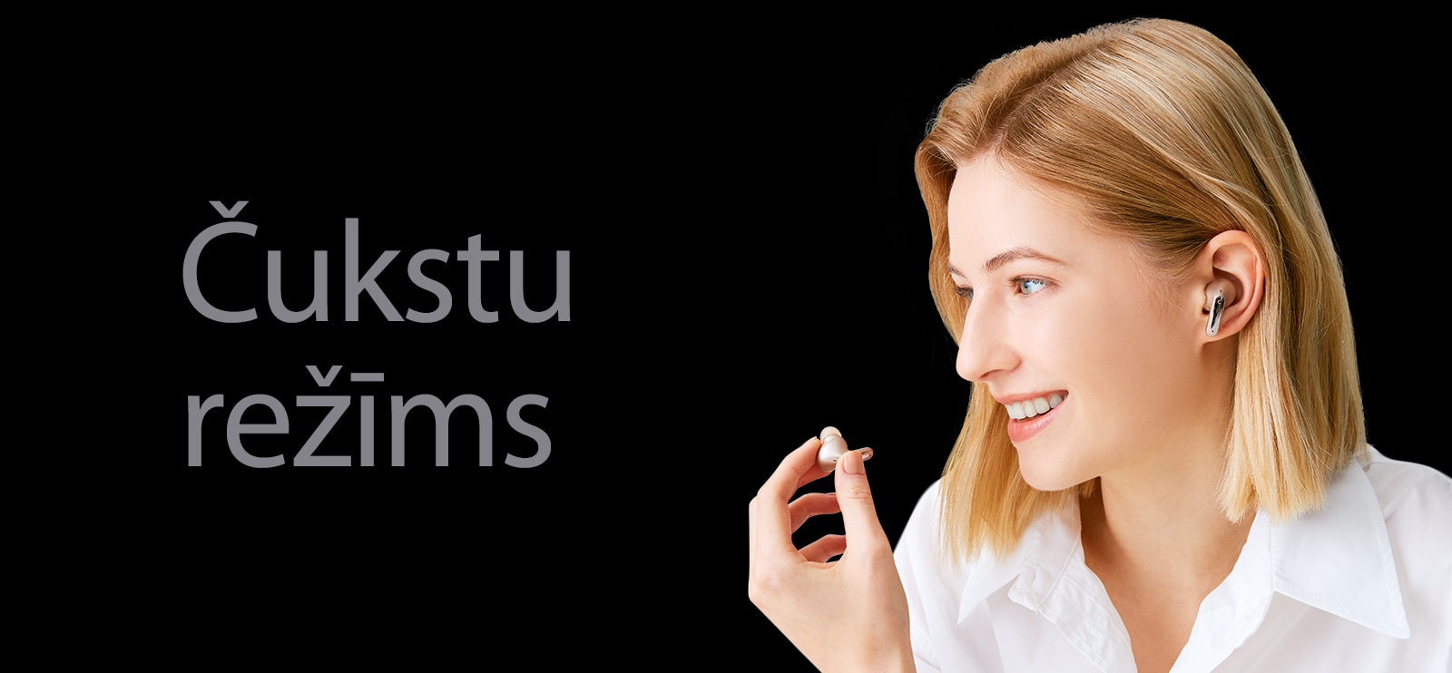 Attēlā redzama sieviete, kas rokā tur austiņas un izmanto tās kā mikrofonu zvana veikšanai.