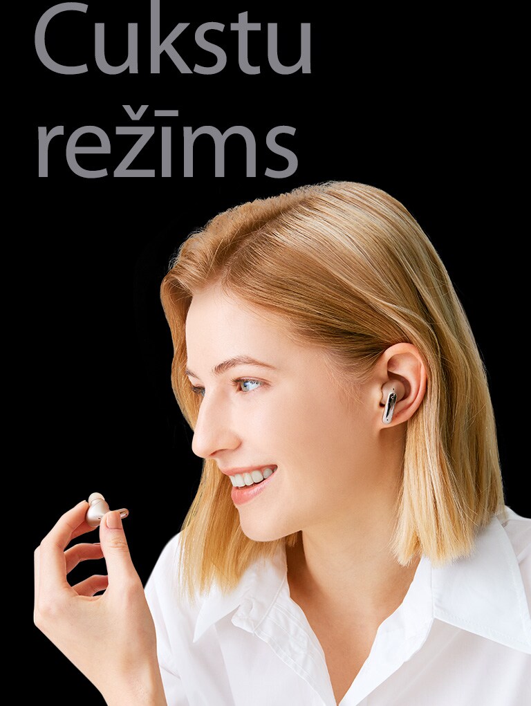 Attēlā redzama sieviete, kas rokā tur austiņas un izmanto tās kā mikrofonu zvana veikšanai.