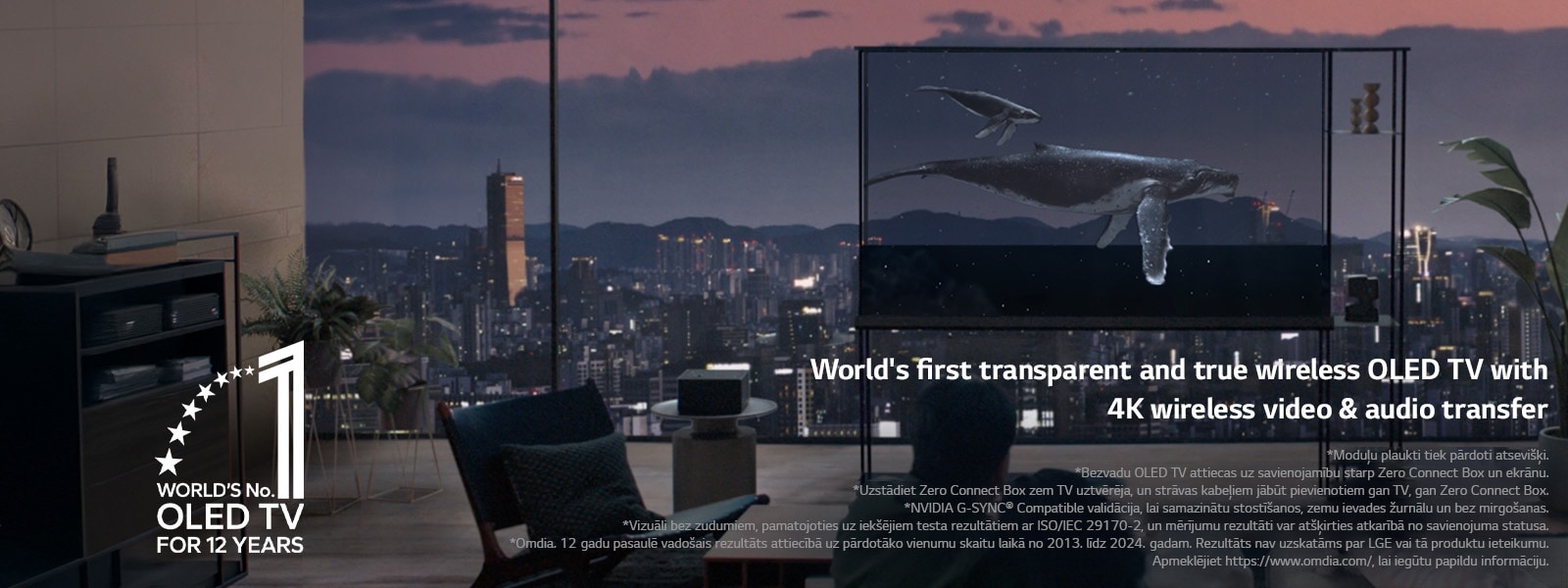 Valis peld pāri LG SIGNATURE OLED T, kamēr ēna tiek novilkta, lai parādītu vakara pilsētas panorāmu. Cilvēki sēž uz dīvāna priekšplānā ar seju pret TV un logu. Zero Connect Box atrodas uz neliela galdiņa pa kreisi no TV. 