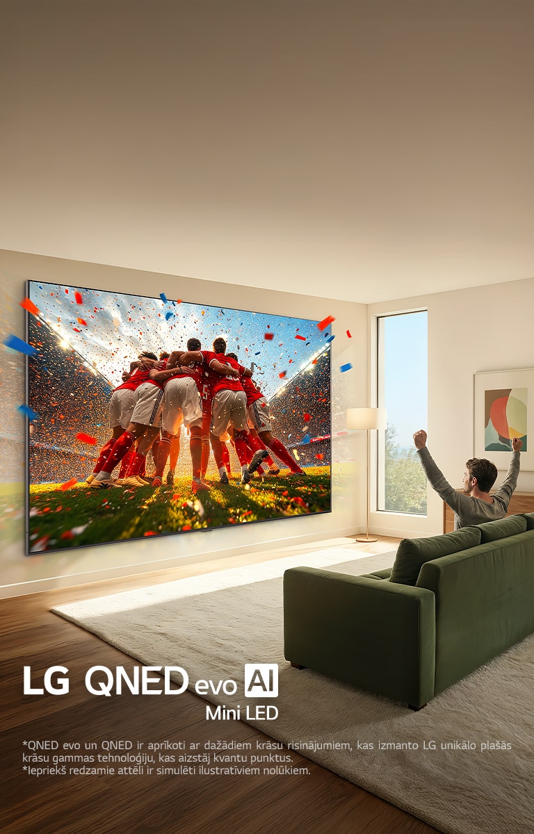 LG QNED evo AI Mini LED Ultra Big TV uzstādīts pie sienas viesistabā. Vīrietis sēž uz dīvāna un jūsmo par savu komandu. Sporta saturs ekrānā izskatās tā, it kā tas izlauztos ārpus ekrāna, demonstrējot aizraujošu un izbaudāmu pieredzi pie liela ekrāna.