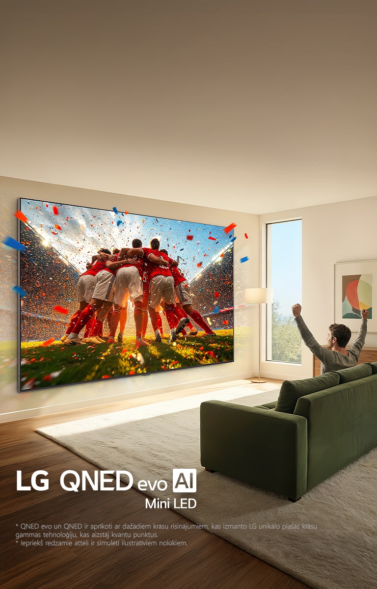 LG QNED evo AI Mini LED Ultra Big TV uzstādīts pie sienas viesistabā. Vīrietis sēž uz dīvāna un jūsmo par savu komandu. Sporta saturs ekrānā izskatās tā, it kā tas izlauztos ārpus ekrāna, demonstrējot aizraujošu un izbaudāmu pieredzi pie liela ekrāna.