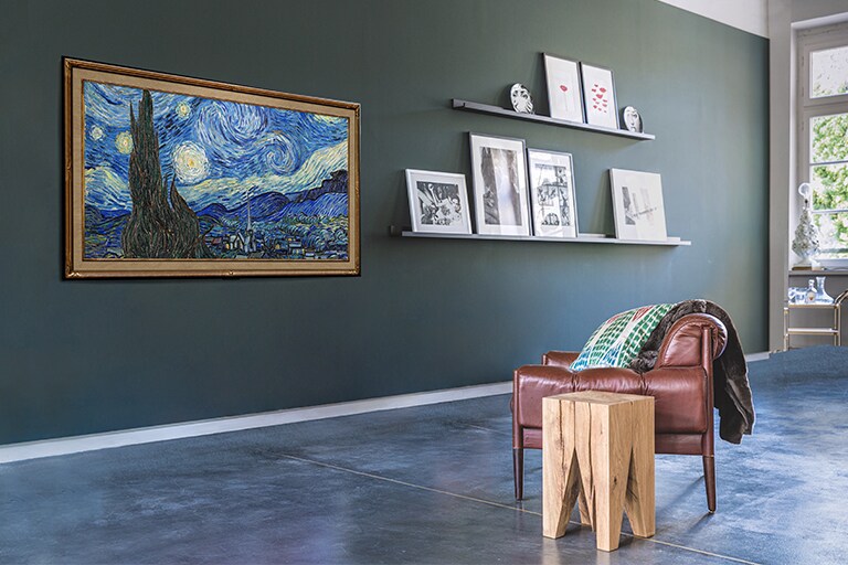 Attēls ar pie sienas piestiprinātu Gallery Design televizoru, kurā redzams mākslas darbs viesistabā.