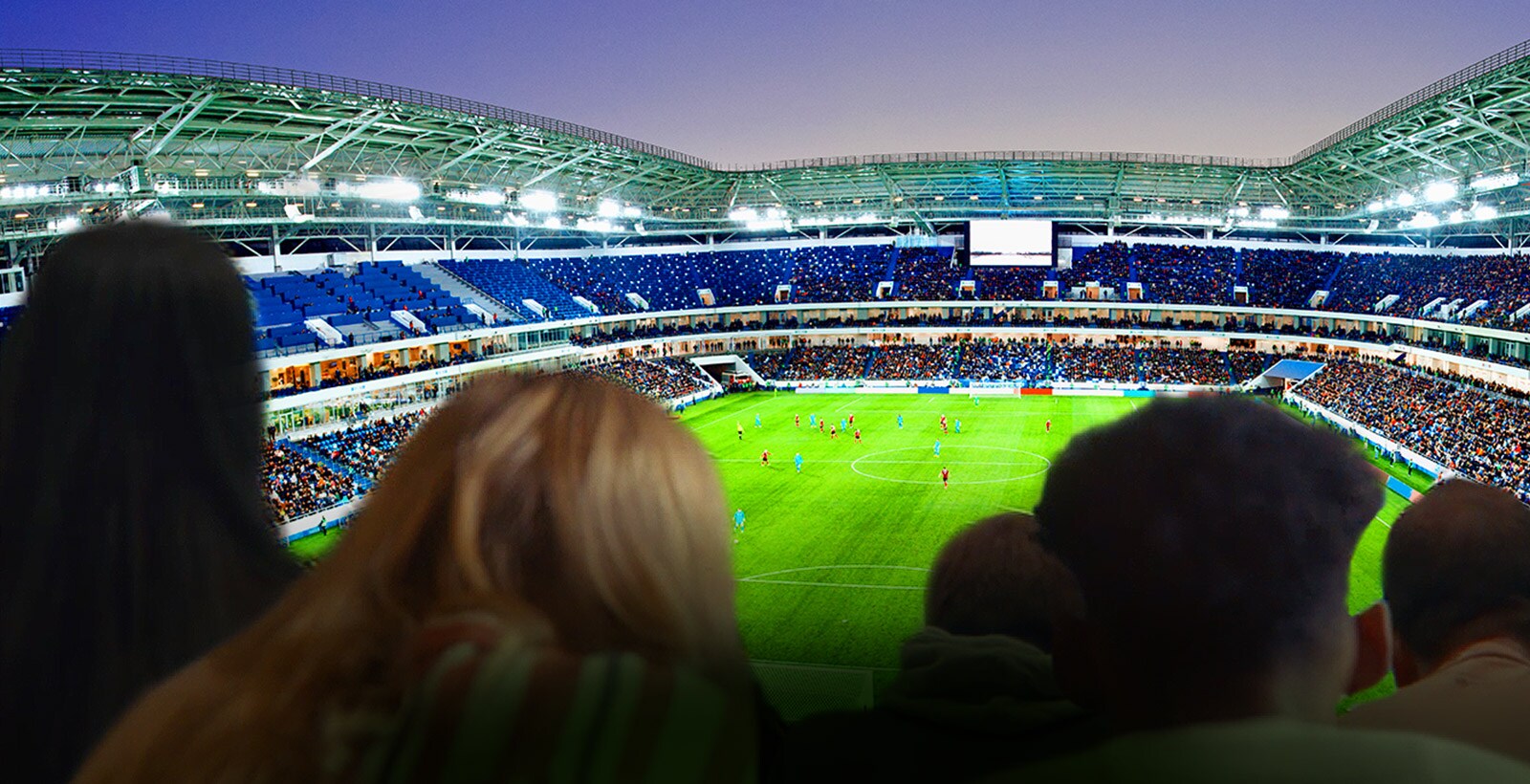 Cilvēki lielā televizorā skatās futbola spēli ar visu stadionu fonā (ritiniet lejup lapu)