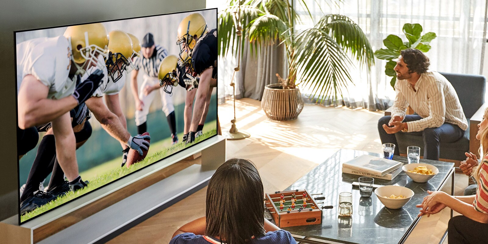 Draugu kompānija viesistabā televizorā skatās futbola spēli