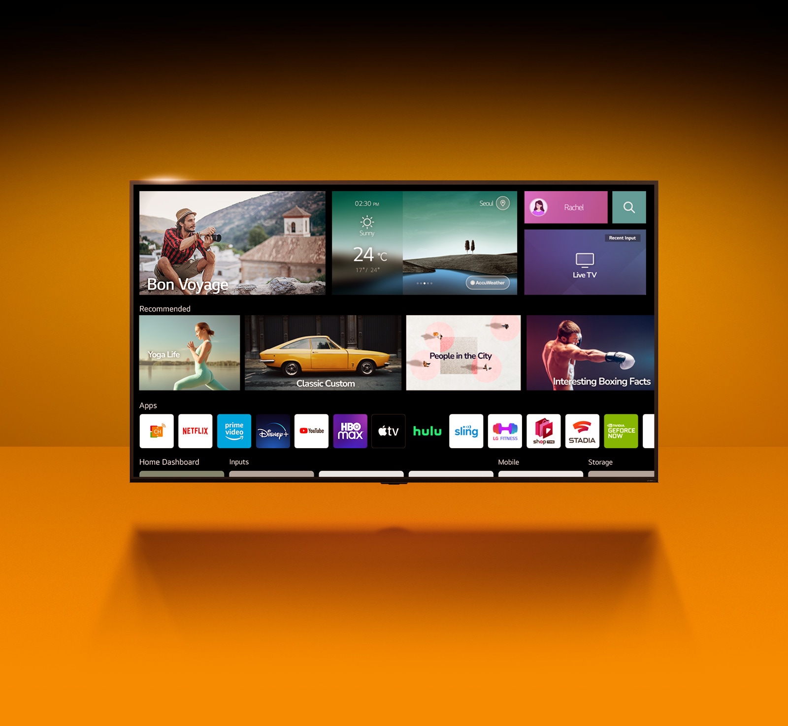 Pie oranžas sienas stāv televizors. Televizorā ir redzams sākuma ekrāns, un ir izcelti APP saraksti.