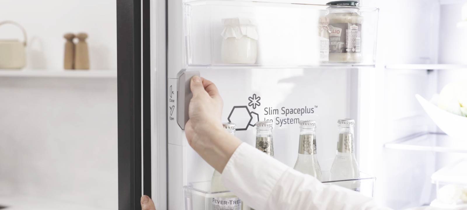 Lietotājs atver Slim SpacePlus Ice System nodalījumu LG ledusskapī