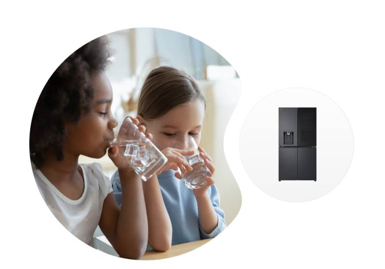 Divi bērni dzer ūdeni pie galda, fonā redzams LG ledusskapis un iebūvēts dozators