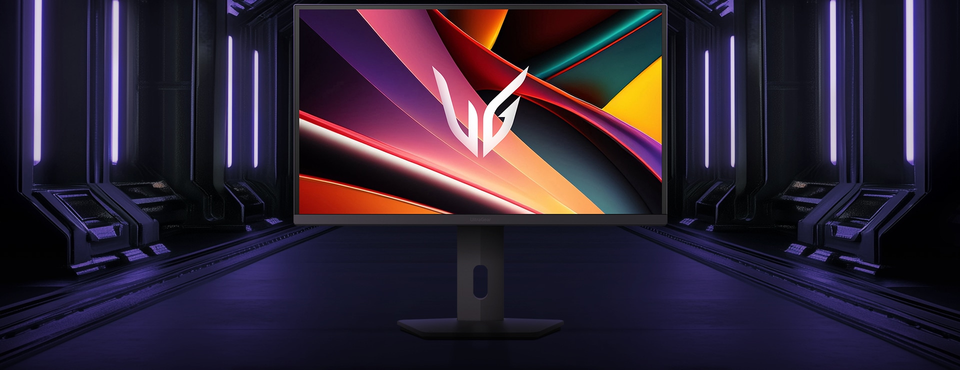 LG UltraGear™ 27G610A spēļu monitora priekšējais skats uz sešstūra pamatnes futūristiskā, neona apgaismotā koridorā; ekrānā redzami spilgti violeti un sarkani virpuļi ar UltraGear logotipu centrā.