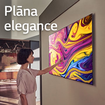 Sieviete skatās televizorā, kas piekārts pie sienas un attēlo mākslas darbu.