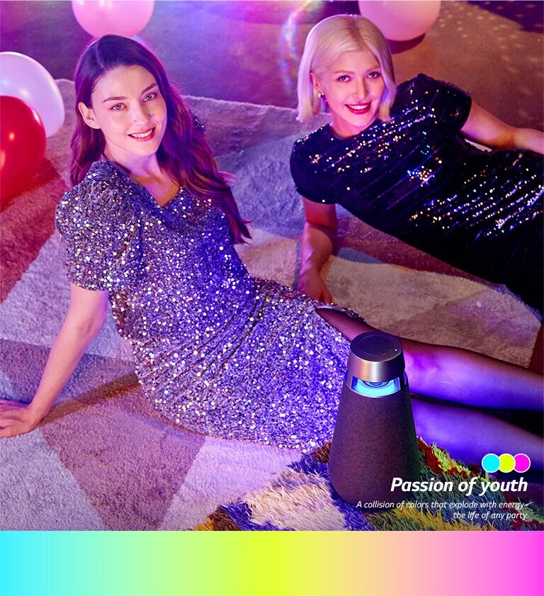 Divas sievietes sēž uz grīdas un smaida ballītē ar XO3 ballīšu režīma iestatījumu.