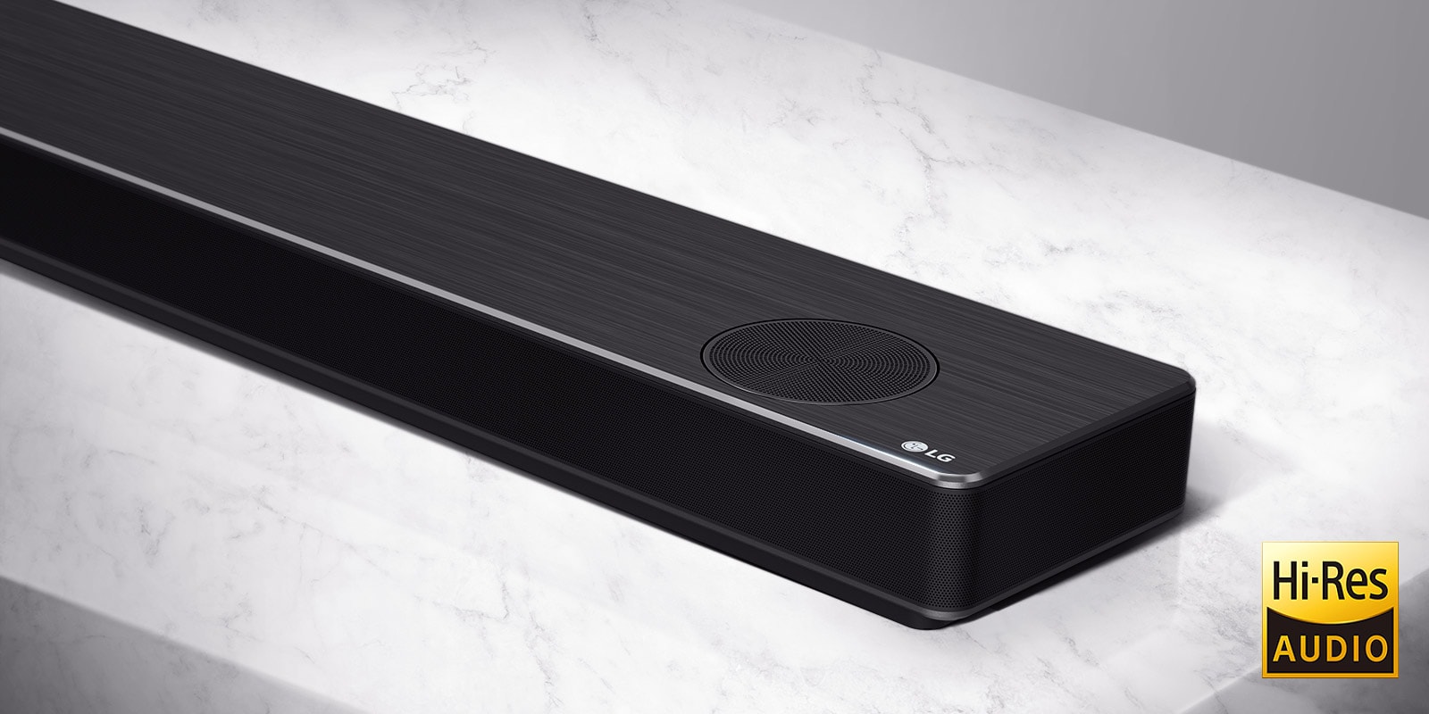 Tuvplānā LG Soundbar labā puse ar LG logotipu produkta apakšējā labajā stūrī.