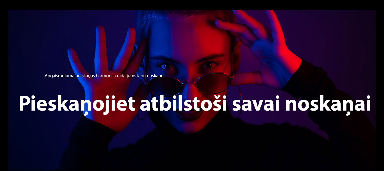 Sieviete pozē spilgtā apgaismojumā.