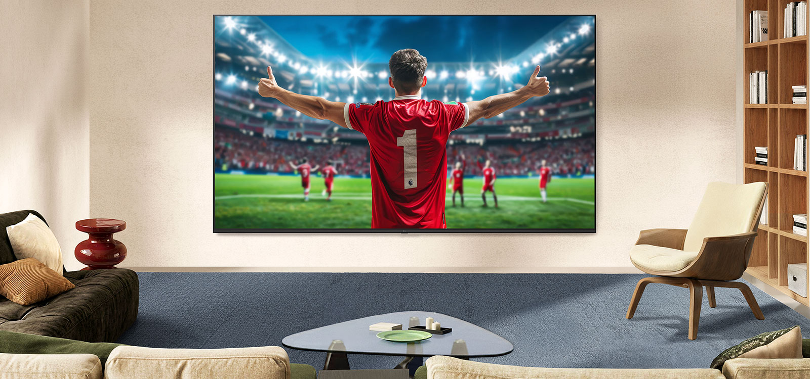 LG NANO 4K UHD AI NU80 Ultra Big TV ekrāns piestiprināts pie sienas istabā, attēlojot futbolista svinības stadiona centrā spilgtu arēnas gaismu apgaismojumā un uzsverot dzīvīgas krāsas, skaidrību un iespaidīgu mērogu.