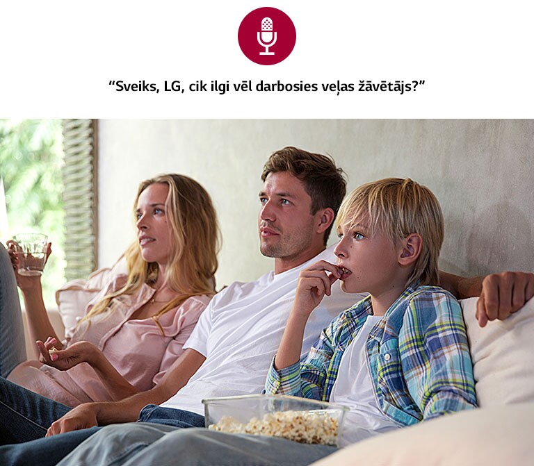 Ģimene uz dīvāna skatās televizoru. Attēlā redzama balss ikona un balss komanda “Sveiks, LG, cik ilgi vēl darbosies veļas žāvētājs?”