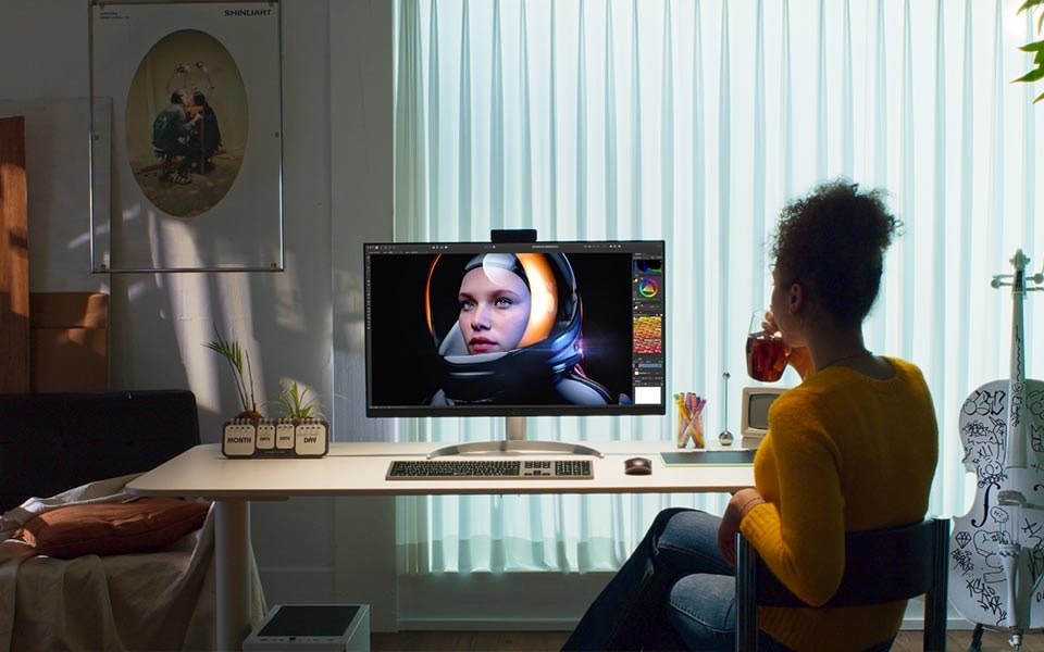 A woman watches a video at her ergonomic setup with the proper monitor height