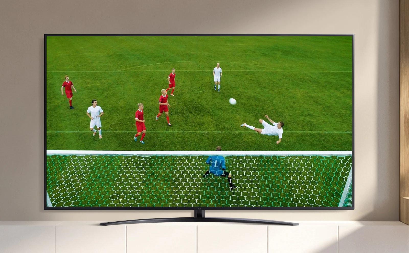 La pantalla de un televisor reproduce un video de un jugador de fútbol haciendo un gol durante un partido de fútbol. (reproducir el video)