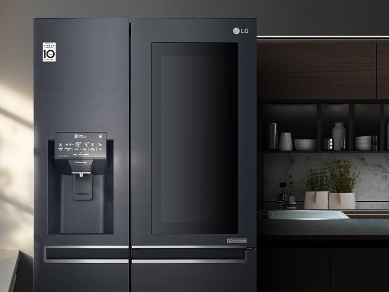 The slider has been pulled to the right to reveal the refrigerator installed in a kitchen with the Door-in-Door mirrored glass panel dark.