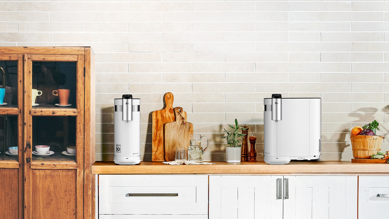 Two water purifiers are shown in a kitchen. One is shown with the thin end forward and the tap on that side. The second is shown with the tap on the longer side to show the possibilities.