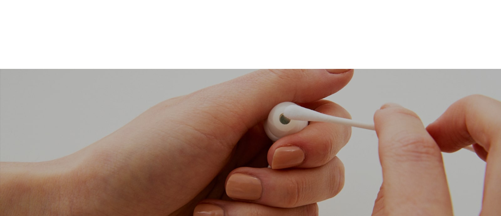 Een afbeelding van het in de hand houden van de oordopjes en het afvegen van de oordopjes met een wattenstaafje, waarmee de bacteriën in de oordopjes tot uitdrukking wordt gebracht.
