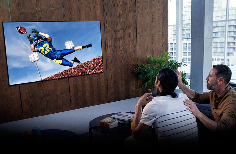 Mensen kijken naar het spel van Tottenham op tv in de woonkamer