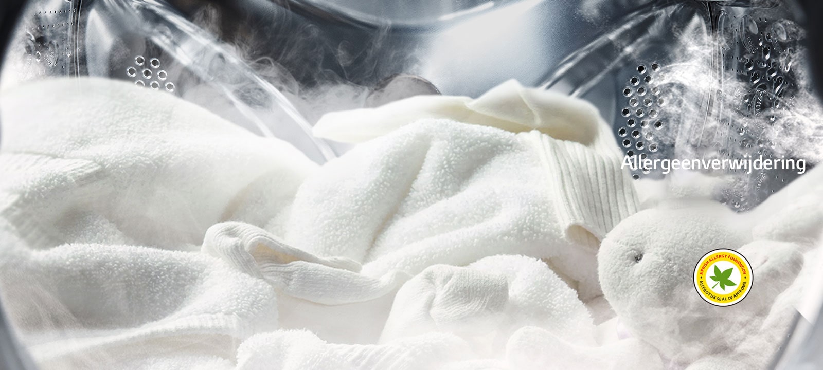 Een zachte witte badjas en een knuffeldier worden getoond met stoom in de trommel van de wasmachine.