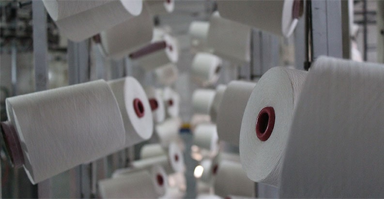 Bilde av bomullstråder i tekstilfabrikk