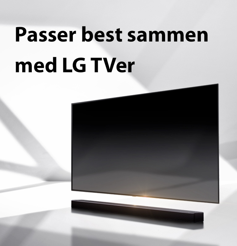 En lydplanke og en TV er plassert på et hvitt gulv og det er en skygge som kommer utenfra like bak.