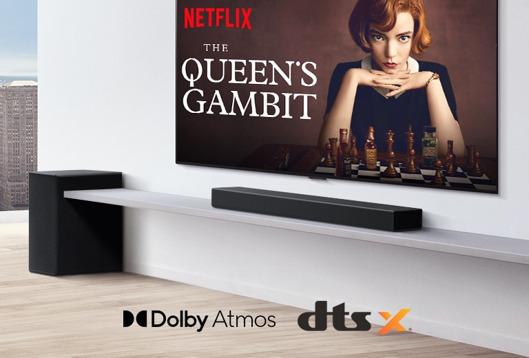 TVen er på veggen.  En plakat av en TV vises på TV-skjermen. LG Lydplanke er direkte under TV på en hvit hylle med subwoofer rett ved siden av. Logo av Dolby Atmos og DTS:X vises nederst, midt på bilde.